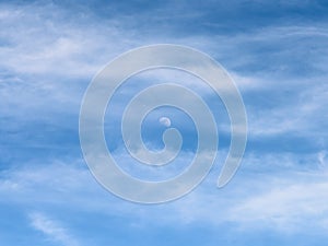 Moon Visible In Daylight Blue Sky With White Clouds