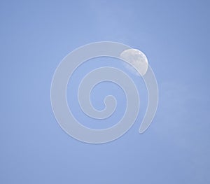 The moon visible in the daytime sky.