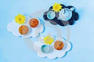 Mooncake, blue teapot, yellow chrysanthemum flowers. Chinese mid-autumn festival food