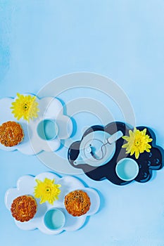 Mooncake, blue teapot, yellow chrysanthemum flowers with copy space. Chinese mid-autumn festival food