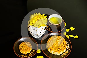 Mooncake and tea, Chinese mid autumn festival food isolated on black background