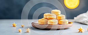 Mooncake on wooden plate on dark night background with moon and stars. Mid-autumn festival and Chinese New Year photo