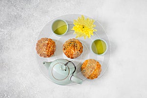 Mooncakes, blue teapot, yellow chrysanthemum flowers and cup of green tea. Chinese mid-autumn festival food