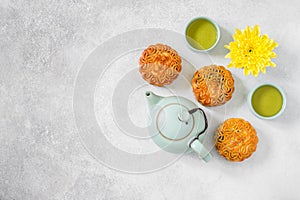 Mooncakes, blue teapot, yellow chrysanthemum flowers and cup of green tea. Chinese mid-autumn festival food