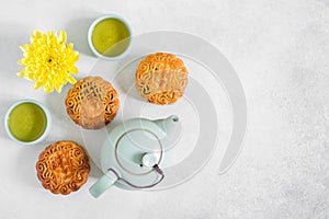 Mooncakes, blue teapot, yellow chrysanthemum flowers and cup of green tea. Chinese mid-autumn festival food