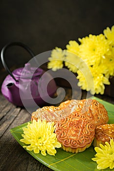 Mooncakes, teapot, yellow chrysanthemum flowers. Chinese mid-autumn festival food