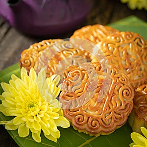 Mooncakes, teapot, yellow chrysanthemum flowers. Chinese mid-autumn festival food