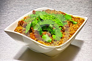Moong Dahl, indian vegetarian lentil soup in white bowl.