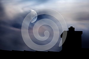 Moonlit clouds above rooftop