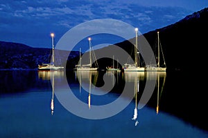 Moonlit sailboats on the sea at night