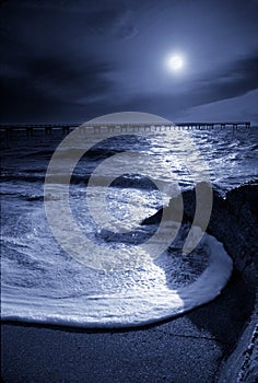 Moonrise Highlights Circular Ocean Wave and Pier in Gulf of Mexico