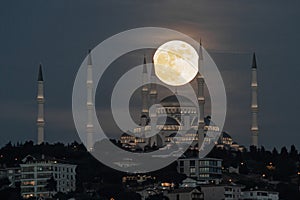 Moonrise over Camlica Mosque in Istanbul, Turkey photo