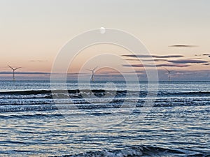 Moonrise over wind farm at Cambois, Northumberland, UK