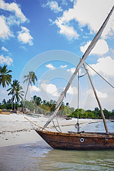 Moored boat on the beach. Wooden local boat on coastline, Zanzibar. Fishing village in Africa.