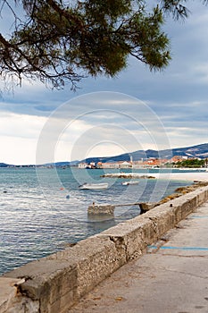 Moored boat. Embankment in Croatia, Kastel Luksic. View of the Adriatic Sea and mountains. In the background is the city of Trogir