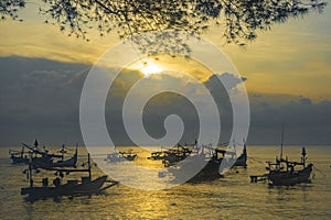 Moored boats during sunrise in Satelit Beach Banyuwangi photo