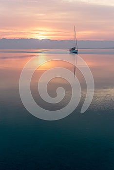 Moored sailboat in the bay and sunrise