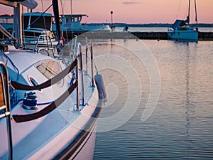 Moored sailing yacht hull and pier, dawn waterscape view