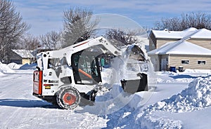 Bobcat skid steer removing snow from driveway