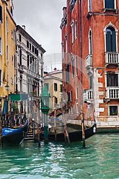 Mooring of gondolas near houses in Venice in rain