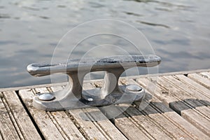 Mooring hook on wooden pier on the river in Finland at summer sunny day