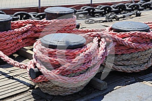 The mooring rope is fixed on the bollard on the deck of the old ship