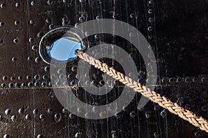 Mooring rope of a large ship standing in the port. Harbor cape w