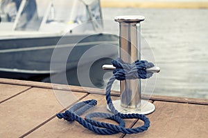 mooring rope on a metal bollard on a boat background