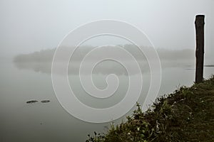 Mooring on the shore of a lake on a misty day in autumn