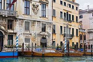 Mooring water taxi near houses in Venice in rain