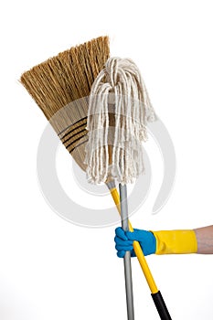 Mop and broom being held by a rubber gloved hand