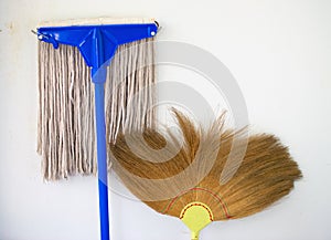 Mop and broom propped against a wall