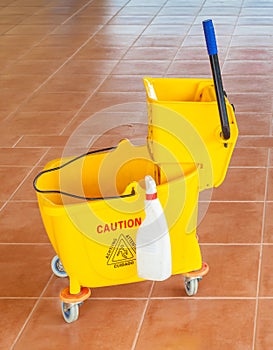 Mop bucket and wringer with caution sign on the floor