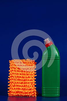 mop cloth and green bottle with reading agent on blue background