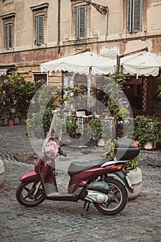 Moped parked on street in front of cafe in Trastevere, Rome, Italy