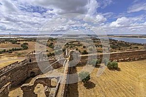 Mora medieval castle view, with Alentejo region tourist destination landscape in the background, Portugal