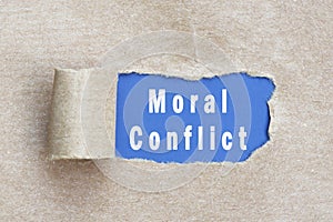 Moral conflict text on brown paper with torn hole.