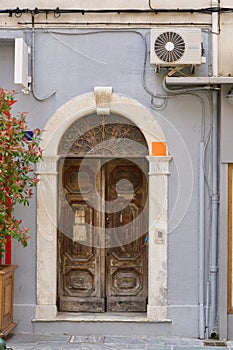 Morbid old wooden door of a grey home