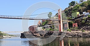 A morden bridge in the Narmada river and omkareshwar temple in the background.