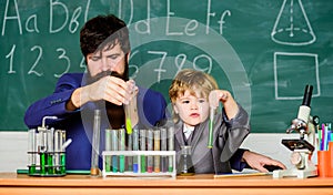 More Intelligence Solutions. man with little boy. Chemistry beaker experiment. father and son child at school