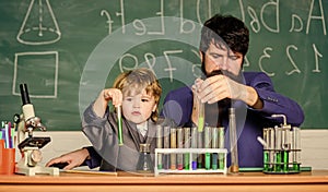 More Intelligence Solutions. man with little boy. Chemistry beaker experiment. father and son child at school