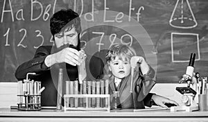 More Intelligence Solutions. man with little boy. Chemistry beaker experiment. father and son child at school