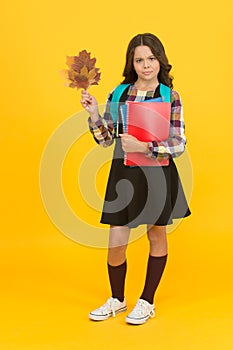 More knowledge never hurt anybody. Cute small girl hold books and autumn leaves. Adorable little child back to school