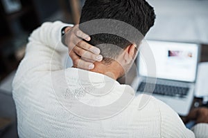 The more stress, the less closer to success. Rearview shot of a young man experiencing neck pain while working from home