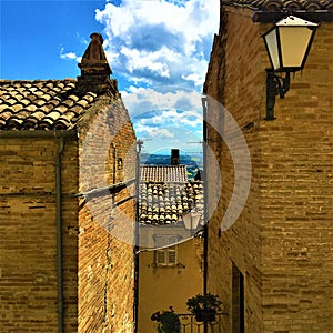 Moresco town in Fermo province, Marche region, Italy. Medieval wall, path, lamp and blue sky