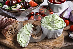 Moretum Roman pesto with greek salad, cherry tomatoes, onions and antipasti on wooden table top view