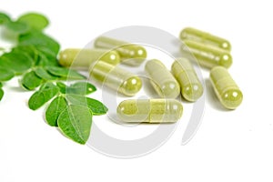 Moringa leaves and capsules on white background