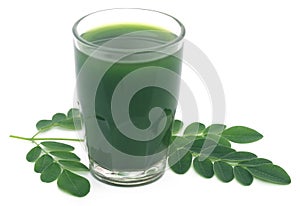 Moringa leaves with extract in a glass photo
