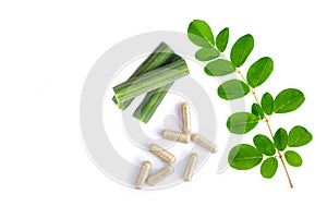 Moringa Oleifera capsules  Horse radish or Drumstick  with fresh green leaves isolated on white .