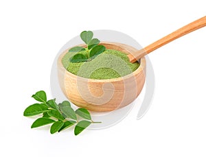 Moringa powder in wooden bowl with  fresh Moringa  leaves  on white background